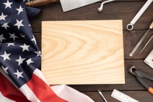 Top view of american flag work tools and blank wooden plank for text template mock up