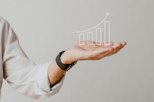 Digital increasing bar graph with businessman hand overlay