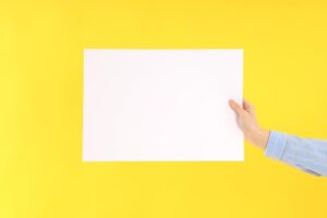 Female hand holding blank banner on yellow background
