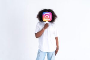 African american teenager holding a instagram logo picture in his hands