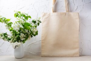 Canvas tote bag mockup with flowering apple tree branch in white vase