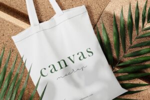Clean minimal bag canvas mockup on plate with leaves background. psd file.