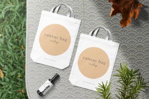 Clean minimal canvas bag mockup on table background with bottle conifer and leaf