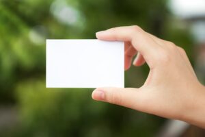 Hand holding a white paper with the background defocused