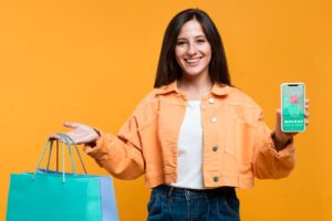 Happy woman holding shopping bags and a phone mock-up