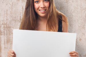 Smiling woman holding a white poster