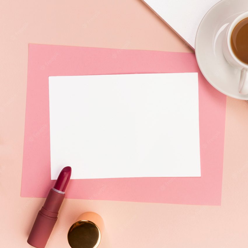 Blank white and pink paper with lipstick,makeup brush and coffee cup