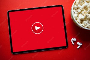 Red video play icon on the screen of tablet concept of watching online videos