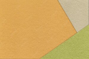 Texture of craft orange color paper background with beige and green border vintage abstract yellow cardboard