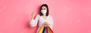 Covid pandemic and lifestyle concept beautiful asian woman shopping in malls in medical mask holding