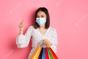 Covid pandemic and lifestyle concept beautiful asian woman shopping in malls in medical mask holding