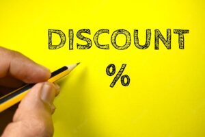 Discount concepttext discount with hand holding pencil on yellow background