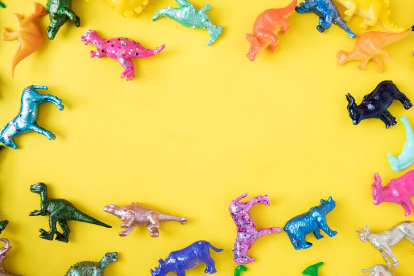 Various animal toy figures in a colorful background and a copyspace