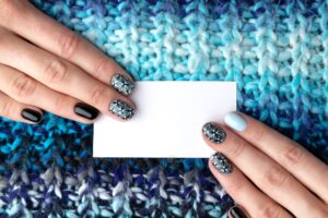 Woman hands with manicure holding business card