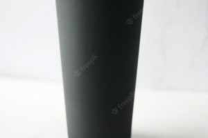 Black color reusable eco coffee cup on table with copy space