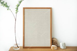 Blank wooden picture frame against a white wall