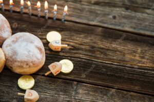 Candles near donuts and hanukkah symbols