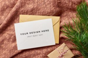 Christmas greeting card mockup with gift box on knitted background