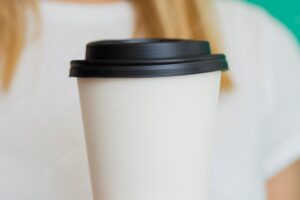 Close-up blonde woman with coffee cup and green background