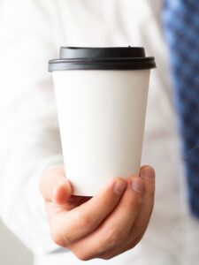 Close-up hand holding coffee cup mock-up