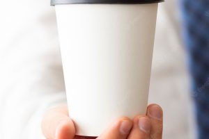 Close-up hand holding coffee cup mock-up