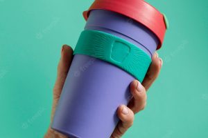 Close up on hand with reusable thermos