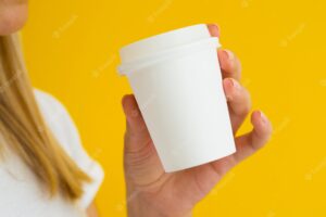 Close-up person holding up drinking coffee