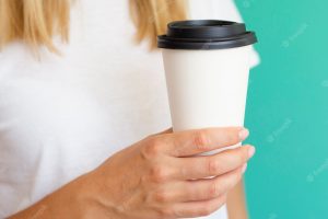 Close-up woman with coffee cup and green background