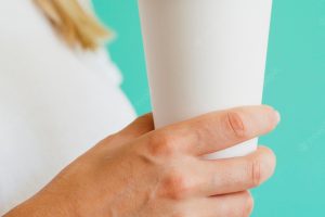 Close-up woman with cup of coffee and green background