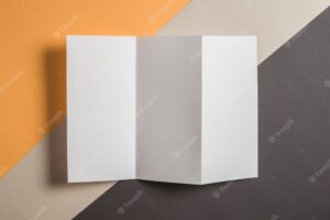 Elevated view of blank white paper on multi colored background