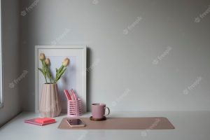 Female workplace with coffee cup smart phone flowers pot and copy space on white table