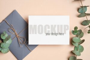 Invitation or greeting card mockup with envelope and green eucalyptus twigs