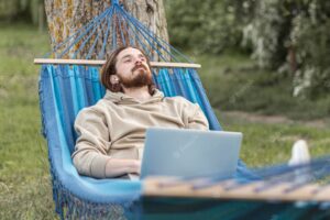 Man relaxing in nature while sitting in hammock