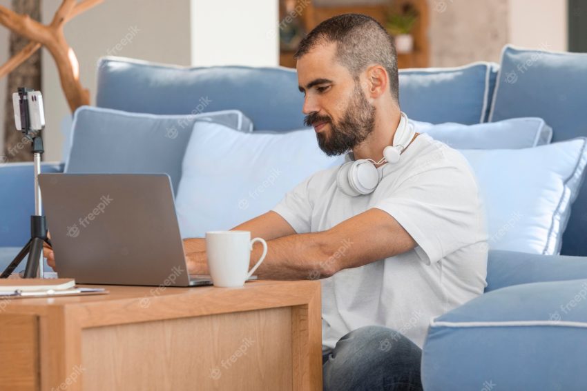 Medium shot man typing on laptop