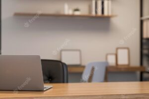 Minimalist bright desk in coworking office room with laptop and copy space on wooden table