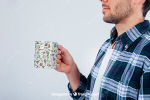 Mock up design with young guy holding coffee mug