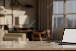 Mock up laptop with copy space over blurred modern dark office workspace background