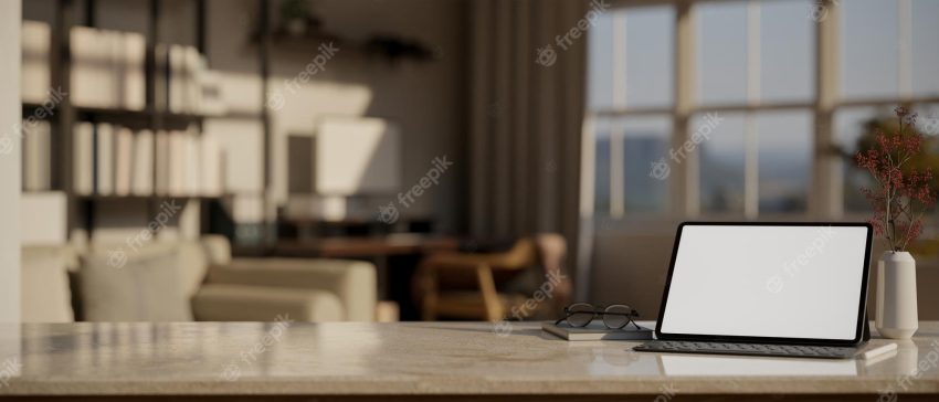 Mock up laptop with copy space over blurred modern dark office workspace background