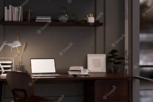 Modern dark office working space at night with laptop mockup office supplies and decor on table