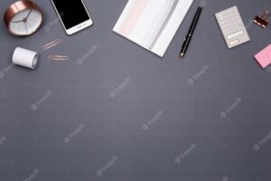 Office table desk with smartphone and other office supplies on grey background. top view