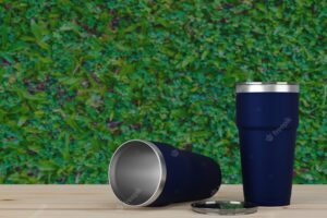 Stainless steel thermos tumbler cup cold mug storage with green leaf bokeh background 3d rendering