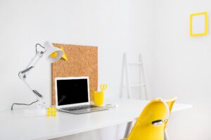 Stylish workspace with cork board and yellow chair