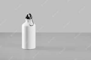 White aluminum water bottle isolated on light gray background with copy space for text. minimalism, reuse and recycling of materials