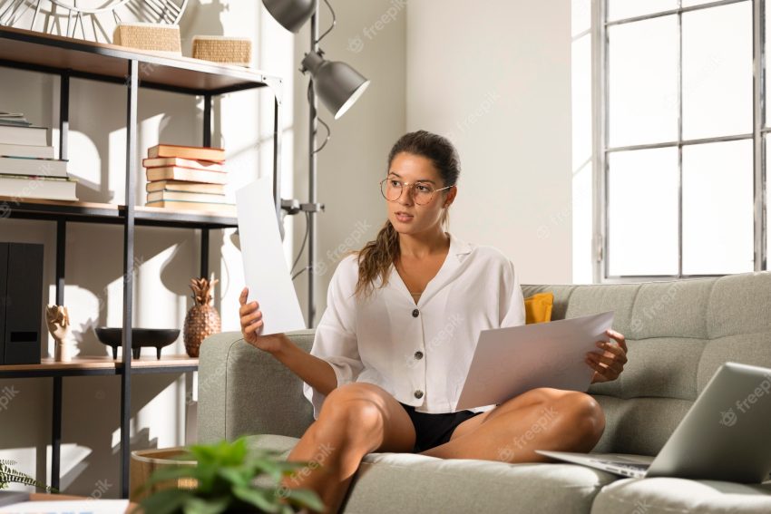 Woman on couch holding papers