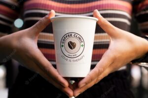 Woman holding a disposable cup of coffee