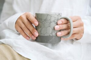 Woman holding a japanese pattern coffee cup psd mockup, remix of