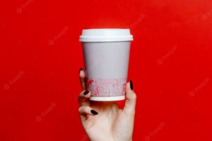 Woman holds plastic cup of coffee