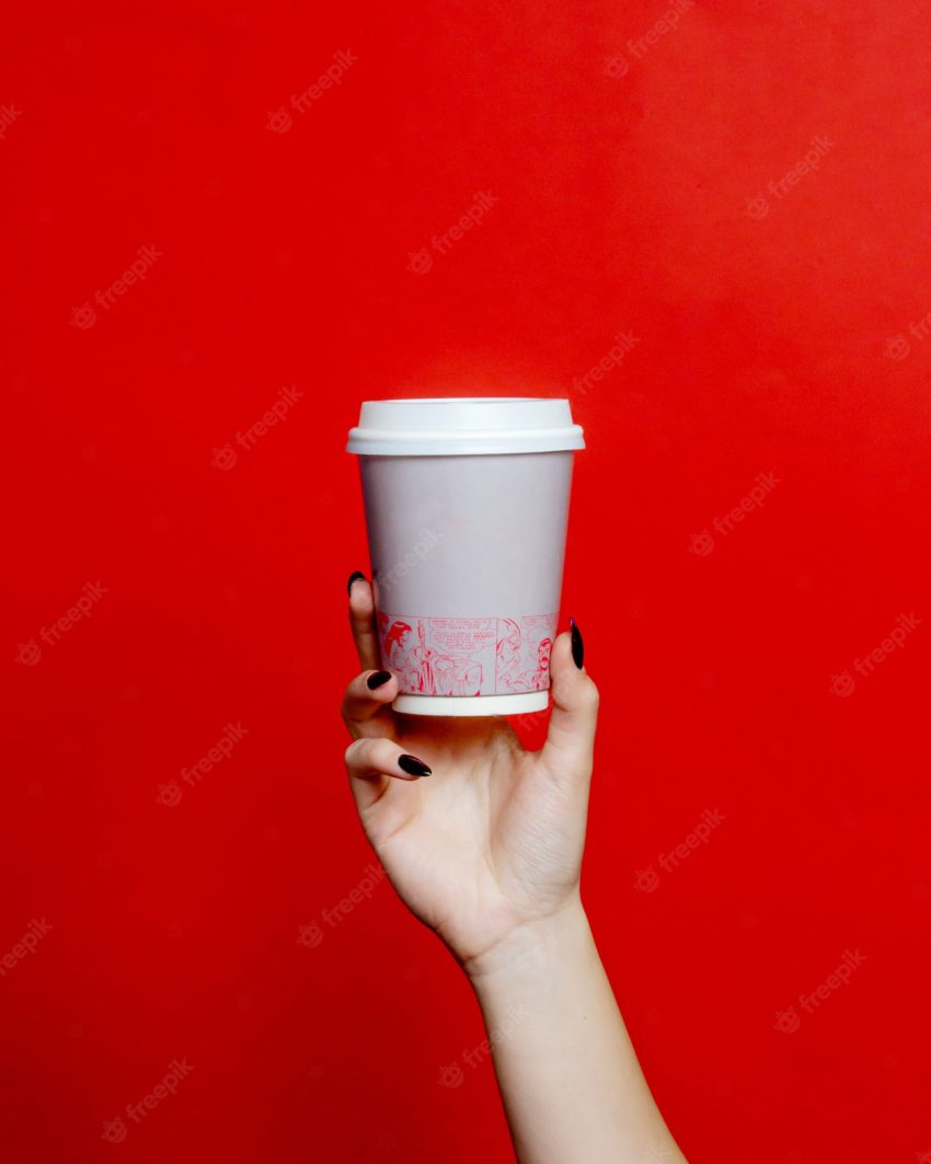 Woman holds plastic cup of coffee
