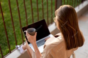 Woman at home in quarantine working with laptop outdoors