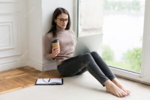 Woman sitting on the floor working on her laptop